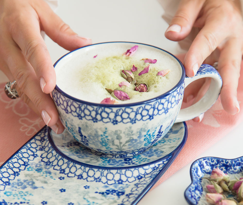 Een Bunzlau Castle kopje met een matcha latte met rozenblaadjes.