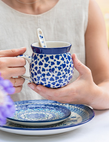 Bunzlau Castle mok in decor Dancing Hearts met lepel en blauw servies op tafel